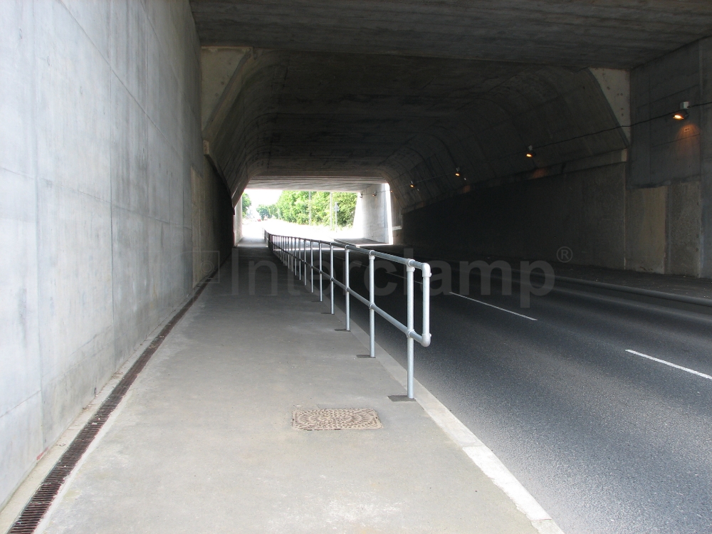 Busy main road featuring Interclamp standard safety stanchion posts, providing essential safety measures for pedestrians.